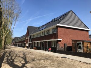 Straatbeeld lange straat, rijtjeshuizen met luifels en zelfdragende goten van Meilof Riks bv.